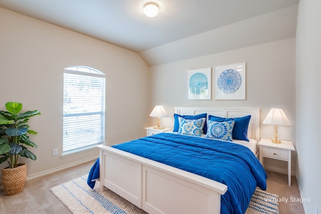 bedroom with baseboards, lofted ceiling, and light carpet