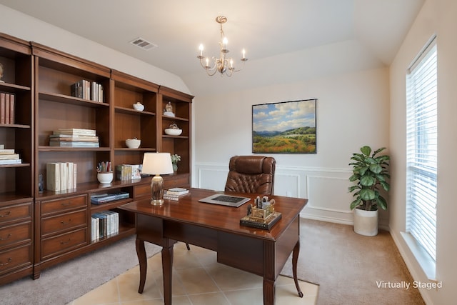 office area with visible vents, a notable chandelier, a decorative wall, lofted ceiling, and light colored carpet