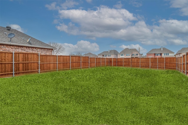 view of yard featuring a residential view and a fenced backyard