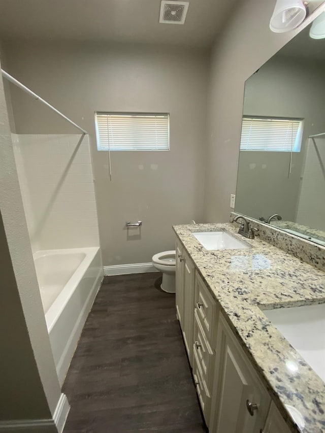 full bathroom featuring visible vents, toilet, a sink, wood finished floors, and baseboards