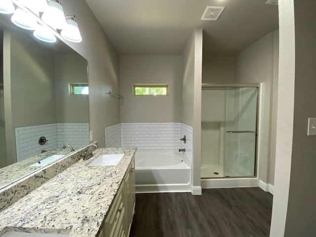 full bath with vanity, a stall shower, wood finished floors, and visible vents