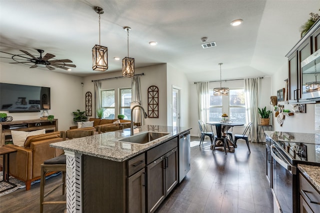 kitchen featuring a healthy amount of sunlight, dark wood finished floors, stainless steel appliances, and a sink