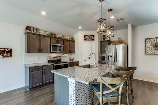 kitchen with decorative backsplash, dark wood-style floors, appliances with stainless steel finishes, dark brown cabinets, and a sink