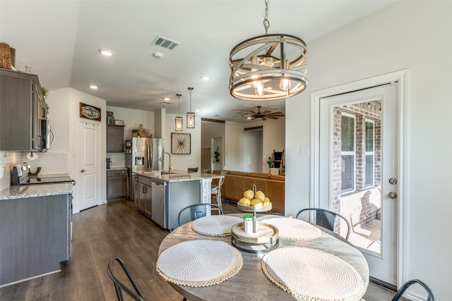 dining space with ceiling fan with notable chandelier, visible vents, dark wood-type flooring, and recessed lighting