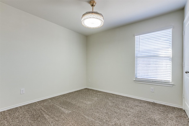 carpeted spare room with baseboards