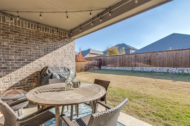 view of patio / terrace with outdoor dining area, a fenced backyard, and a grill