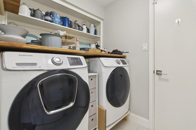 washroom featuring laundry area, baseboards, washer and dryer, and light tile patterned flooring