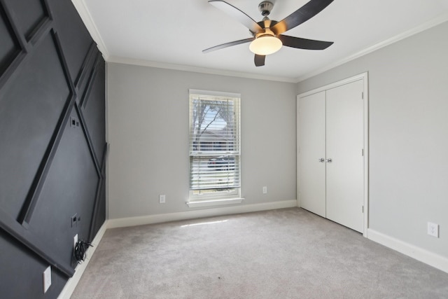 unfurnished bedroom featuring a closet, light colored carpet, crown molding, and baseboards