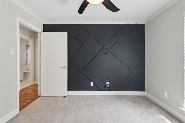 carpeted empty room featuring crown molding, baseboards, and ceiling fan