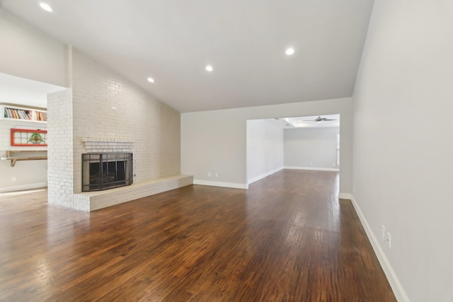 unfurnished living room with vaulted ceiling, dark wood-type flooring, a fireplace, and a ceiling fan