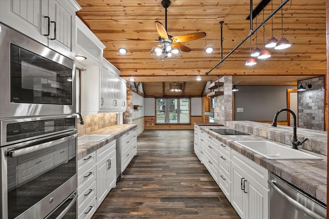 kitchen featuring dark wood-type flooring, a sink, wood ceiling, white cabinetry, and appliances with stainless steel finishes