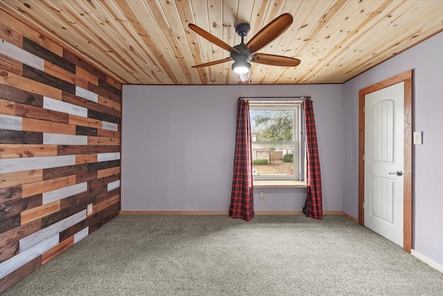 unfurnished room with wooden ceiling, wood walls, ceiling fan, and carpet floors