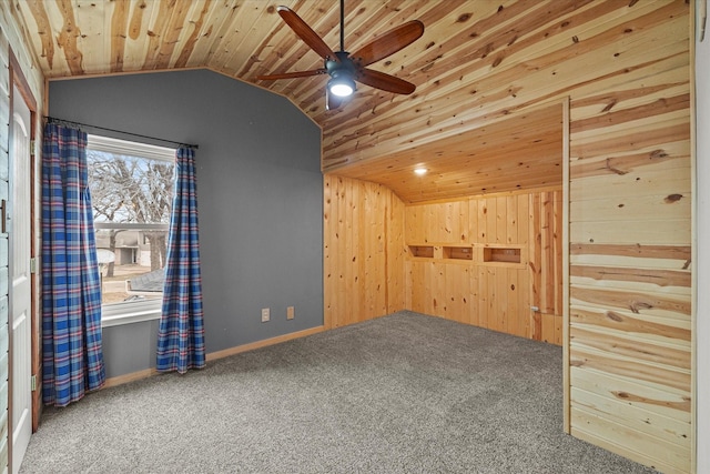 interior space with a ceiling fan, lofted ceiling, wooden ceiling, and wooden walls