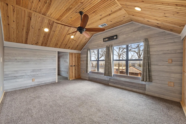 additional living space with lofted ceiling, wood walls, carpet flooring, visible vents, and wood ceiling