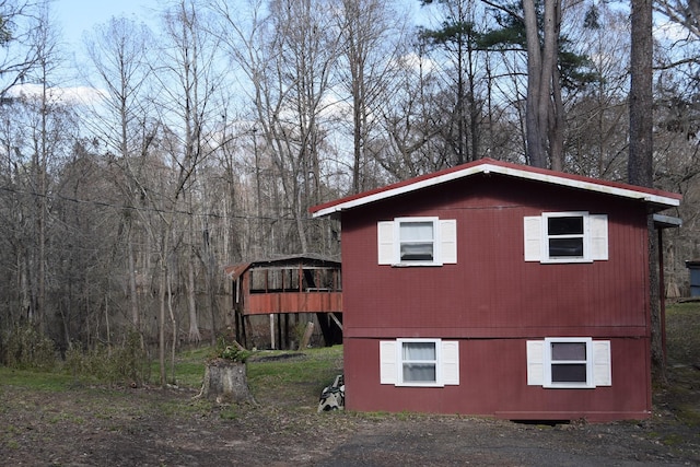 view of property exterior with a wooded view