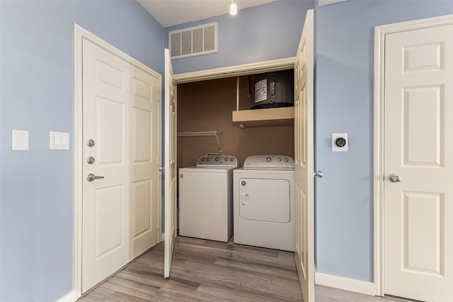 laundry area with wood finished floors, visible vents, separate washer and dryer, laundry area, and baseboards