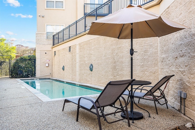 community pool with fence and a patio