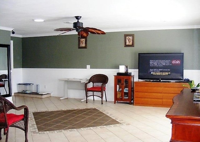 living room with ornamental molding, a wainscoted wall, and ceiling fan