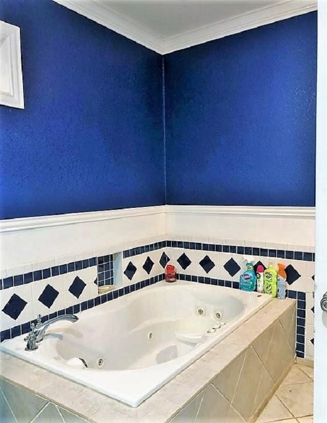 bathroom with a jetted tub, tile patterned flooring, and ornamental molding