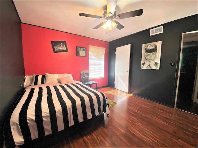 bedroom featuring wood finished floors, visible vents, and a ceiling fan