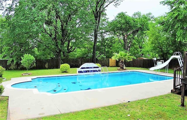 view of swimming pool featuring a fenced backyard, a fenced in pool, a lawn, and a water slide