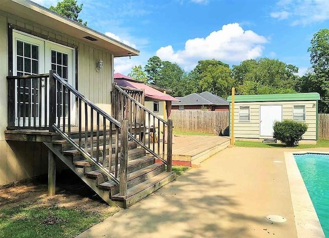 exterior space featuring a fenced in pool, fence, and an outdoor structure