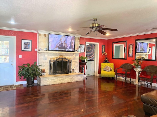 living area featuring ornamental molding, a fireplace, wood finished floors, and visible vents