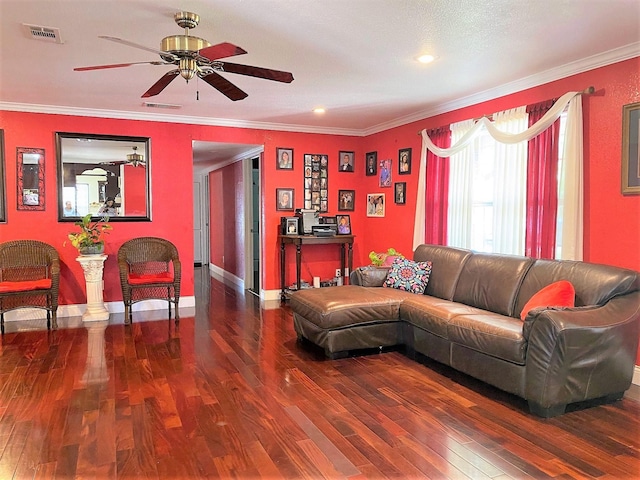 living room featuring ornamental molding, visible vents, baseboards, and wood finished floors