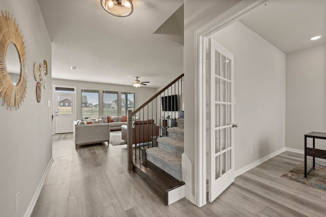 staircase featuring visible vents, ceiling fan, baseboards, and wood finished floors