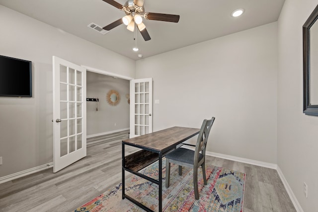 home office with baseboards, visible vents, wood finished floors, and french doors