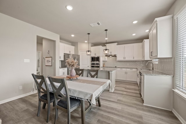 dining room with light wood-style floors, recessed lighting, visible vents, and baseboards