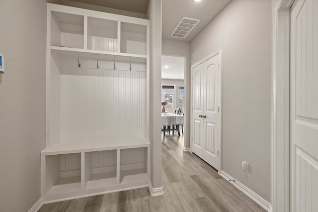 mudroom with wood finished floors, visible vents, and baseboards