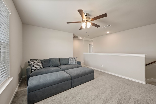 living area featuring visible vents, carpet, attic access, and baseboards