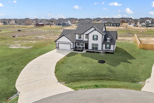 view of front of home with a shingled roof, concrete driveway, a residential view, board and batten siding, and a front yard