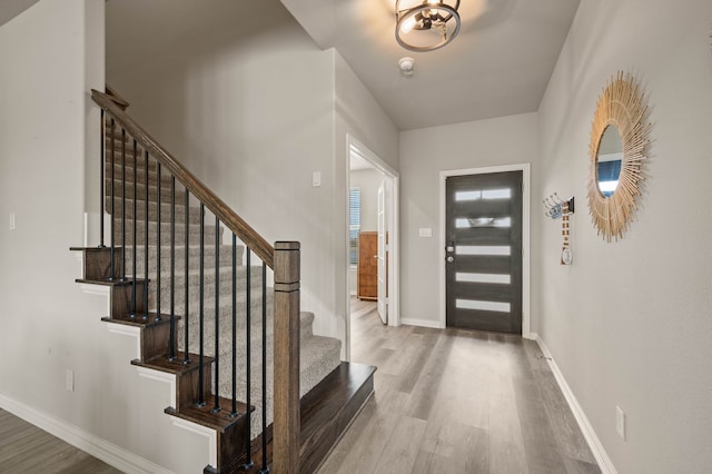 entrance foyer with baseboards and wood finished floors