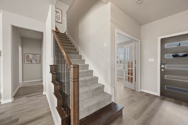 entryway with stairway, baseboards, and wood finished floors