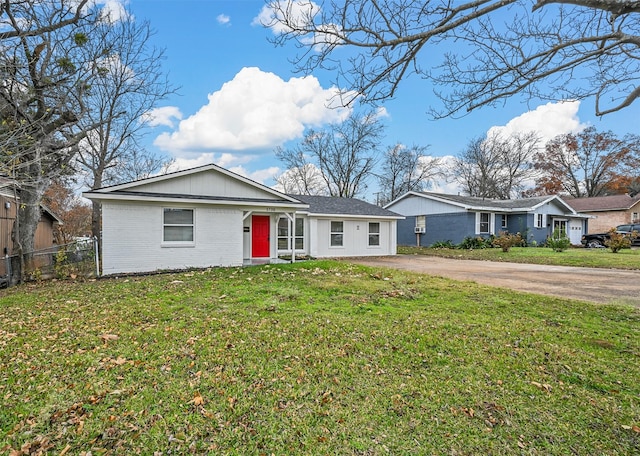 ranch-style home with driveway, a front lawn, fence, and brick siding