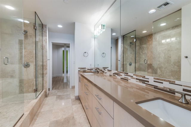 bathroom featuring double vanity, a stall shower, visible vents, and a sink