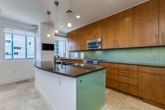 kitchen with stainless steel appliances, dark countertops, a sink, and decorative backsplash