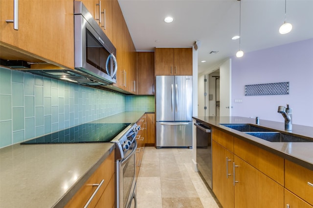 kitchen with decorative light fixtures, stainless steel appliances, decorative backsplash, brown cabinetry, and a sink