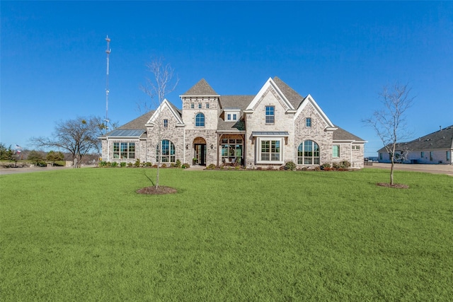 french country home with stone siding and a front yard