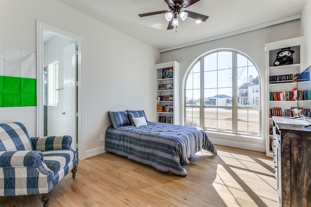 bedroom with baseboards, multiple windows, light wood-style floors, and a ceiling fan