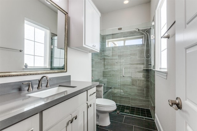 bathroom with tile patterned floors, plenty of natural light, toilet, and a shower stall