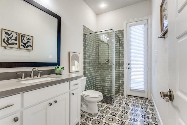 bathroom with toilet, a stall shower, and vanity