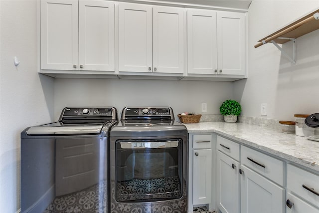 washroom featuring cabinet space and separate washer and dryer