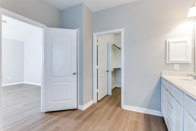 bathroom with wood finished floors, vanity, and baseboards