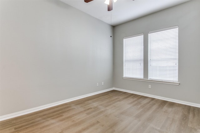 empty room featuring light wood-type flooring, ceiling fan, and baseboards