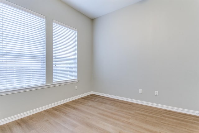 empty room with light wood-style flooring and baseboards