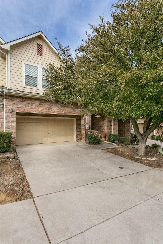 view of front facade featuring a garage, concrete driveway, and brick siding