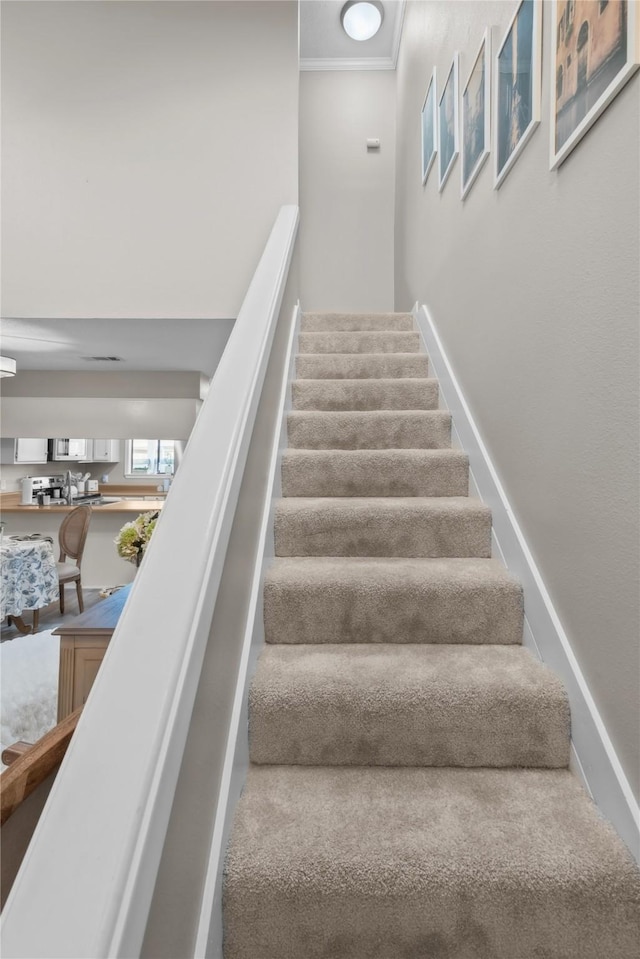 stairs featuring ornamental molding and baseboards